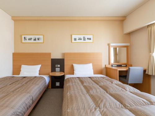 Кровать или кровати в номере The OneFive Okayama