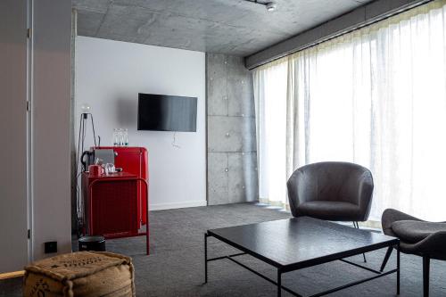 a living room with a red suitcase and a chair at Cukrownia Żnin in Żnin