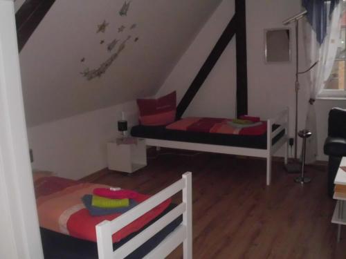 a attic room with two beds and a staircase at Wilhelm Busch Stube in Ebergötzen