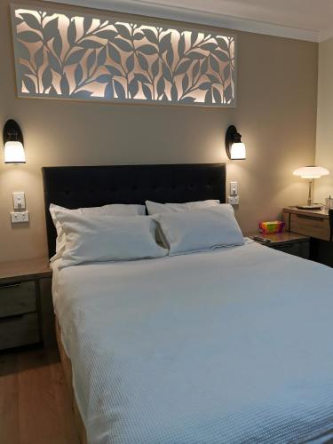 a bedroom with a large white bed with a picture on the wall at BHA unit 6 in Perth