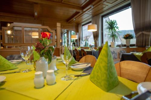 einen Tisch in einem Restaurant mit einem gelben Tischtuch in der Unterkunft Landidyll Hotel Zum Alten Schloss in Kirchensittenbach