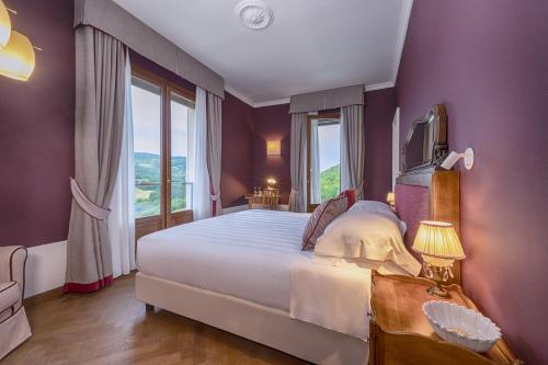 a bedroom with a large bed and a large window at Albergo Posta Marcucci in Bagno Vignoni