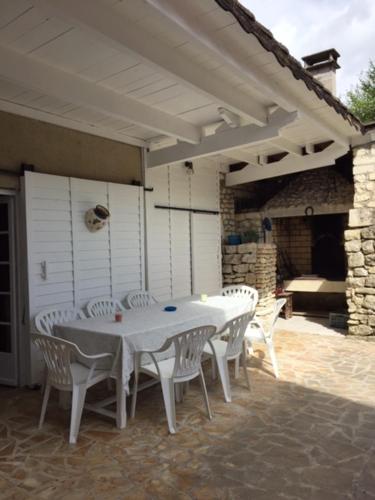 une table blanche et des chaises sur une terrasse dans l'établissement Les Pierrottes, à Mornac