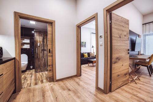 a hallway with a sliding door and a living room at Apartmány Lacov Dom in Klčov