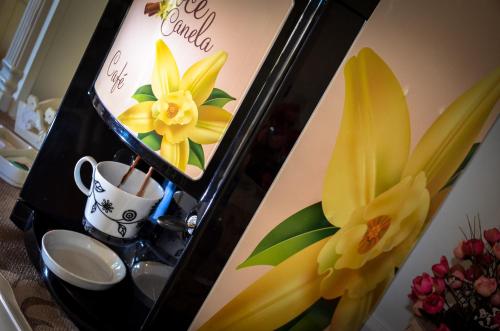 a mirror with a picture of a coffee cup and flowers at Doce Canela - Pousada de Charme in Canela