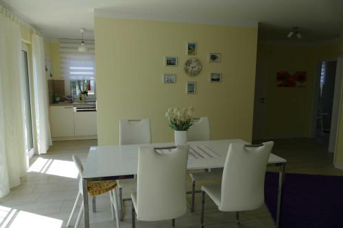 a dining room with a white table and white chairs at Stadtvilla Sommerfrische in Ostseebad Sellin