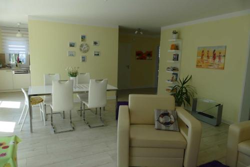 a living room with a table and white chairs at Stadtvilla Sommerfrische in Ostseebad Sellin