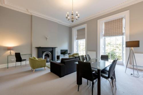 a living room with a table and chairs and a fireplace at Destiny Scotland - Q-Residence in Edinburgh