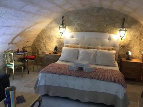 ein Schlafzimmer mit einem großen Bett in einer Steinmauer in der Unterkunft Casa La Palma II La Courmellette in Soissons