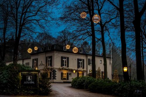 a large white house with christmas lights on it at Hotel Restaurant De Wolfsberg in Groesbeek
