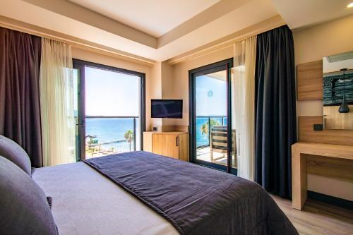 MAIA Luxury Beach Hotel & Spa في غوزيلْتْشاملِ: غرفة نوم مع سرير وإطلالة على المحيط