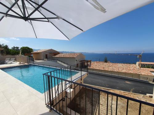 - une vue sur la piscine depuis le balcon d'une maison dans l'établissement St-Florent Appartement neuf vue mer panoramique piscine 4 chambres - MOR401, à Saint-Florent