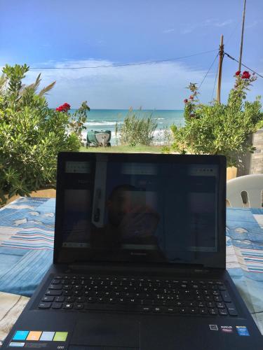 a laptop computer sitting on a table near the beach at Covo dei Marinai in Cava dʼAliga