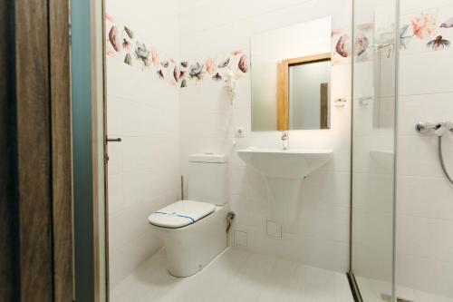a white bathroom with a toilet and a sink at Nicole in Uzhhorod