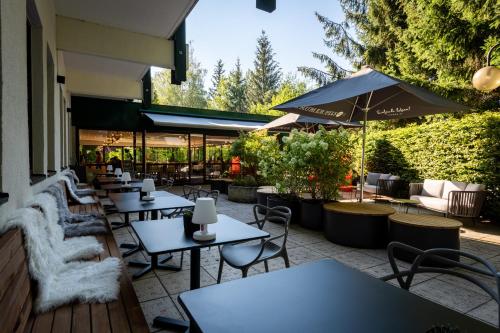 a restaurant with tables and chairs and an umbrella at Alpenland St Johann in Sankt Johann im Pongau