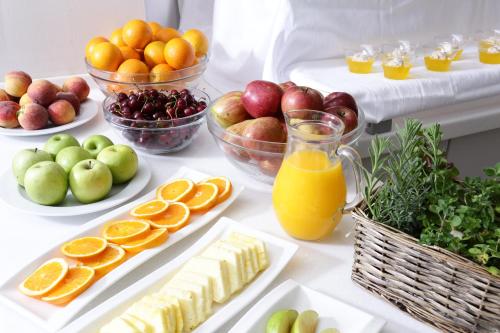 a table topped with plates of fruit and juice at Alexandra Elegance Bridging Generations in Potos
