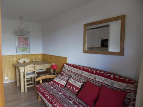 een woonkamer met een bank en een tafel bij travelski home classic - Résidence Themis in La Plagne