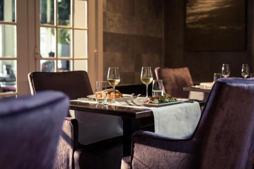 a table in a restaurant with glasses of wine at Hotel Restaurant De Wolfsberg in Groesbeek
