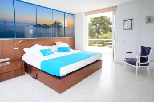 a bedroom with a bed and a desk and a chair at Villa Can Sala in San Antonio Bay