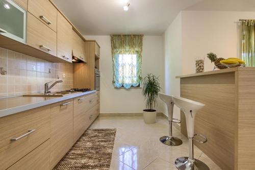 Una cocina con gabinetes de madera y un fregadero. en Villa Sani with private pool near Pula and Rovinj, en Vodnjan