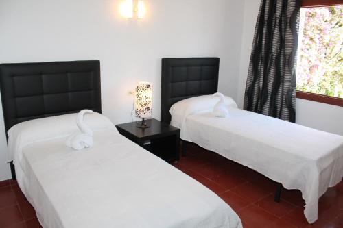 a room with two beds and a window at Can Mossènyer in San Antonio