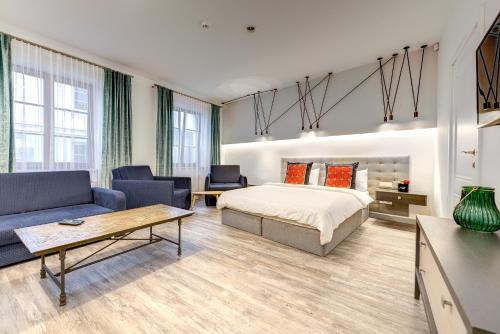 a bedroom with a bed and a couch and a table at Dysnos Avenue Apartments in Vilnius