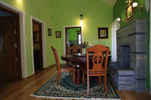 een eetkamer met een tafel en stoelen en een open haard bij Room in Villa - Luxury cottages with beautiful mountain view in Anachal