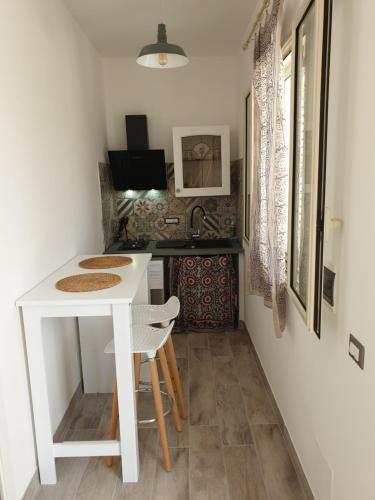 a small kitchen with a white table and a sink at graziosa villetta II in Lampedusa