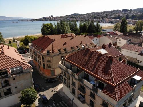 an overhead view of a city with buildings and the ocean at Ático en Moaña- Playa A Xunqueira, a 15 min de Vigo in Moaña