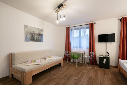 a bedroom with a bed and a desk and a tv at Hotel U Kabinky in Janske Lazne