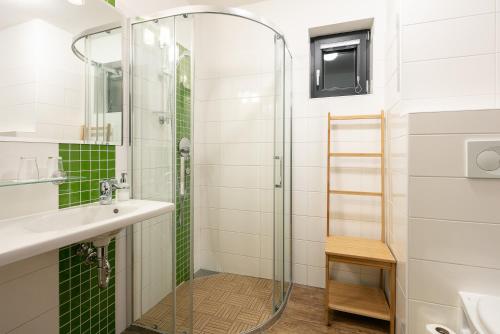 a bathroom with a glass shower and a sink at Hotel U Kabinky in Janske Lazne