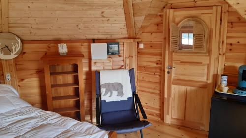 een slaapkamer met een bed en een schilderij van een olifant bij Chalet Finlandais et Sauna 2 pers in Gosnay