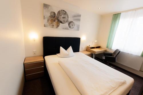 ein Schlafzimmer mit einem großen weißen Bett in einem Zimmer in der Unterkunft PrivatHotel Probst in Nürnberg