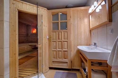 a bathroom with a walk in shower and a sink at Domek regionalny Akwarela centrum sauna in Zakopane