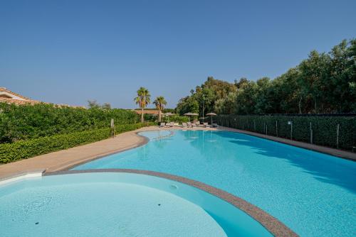 a large swimming pool with blue water at Ville D'Ogliastra in Cardedu