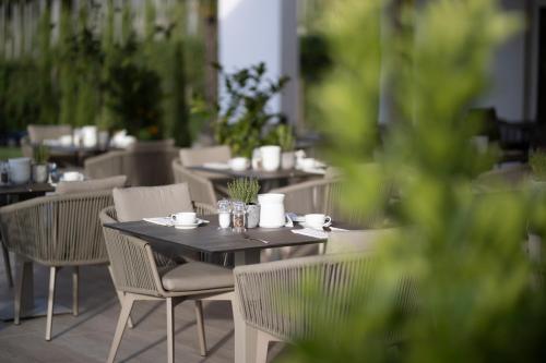 a table and chairs with cups and bowls on it at Hotel MARIA THERESIA adults-only in Lagundo