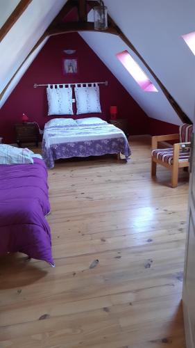 een slaapkamer op zolder met een bed en een bank bij La ferme des 2 chartreuses in Gosnay