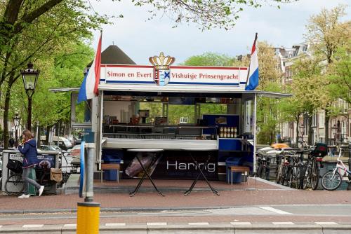 un pequeño quiosco en una calle de la ciudad con bicicletas estacionadas en The Townhouse Hotel, en Ámsterdam
