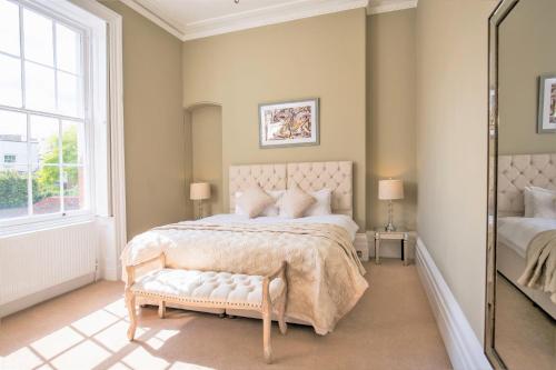 ein Schlafzimmer mit einem großen Bett und einem Spiegel in der Unterkunft Elizabeth House 1 - By Luxury Apartments in Cheltenham