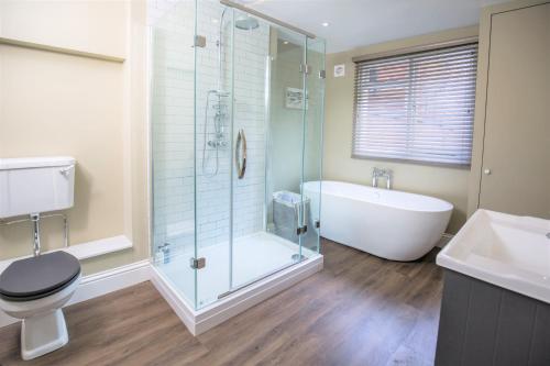 ein Badezimmer mit einer Dusche, einer Badewanne und einem WC in der Unterkunft Elizabeth House 1 - By Luxury Apartments in Cheltenham