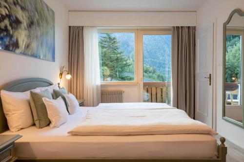 a bedroom with a large bed with a large window at Boutique Hotel St Georgen in Schenna