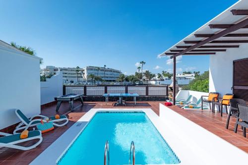 a pool on the roof of a house with chairs and a table at Villa Tara in Tías