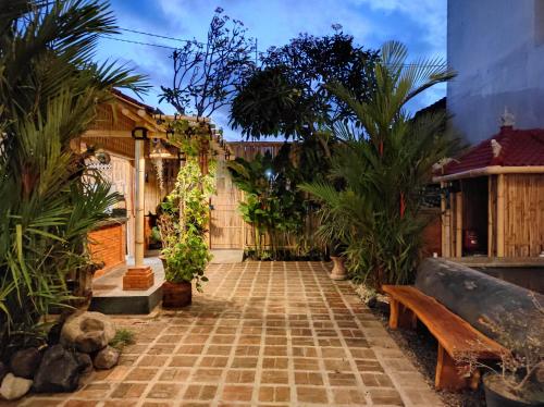 a courtyard with palm trees and a bench at Kubu Di-Kayla's in Sanur