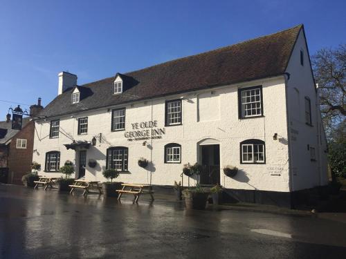 a white building with a sign on the front of it at Ye Olde George Inn - Badger Pubs in Privett