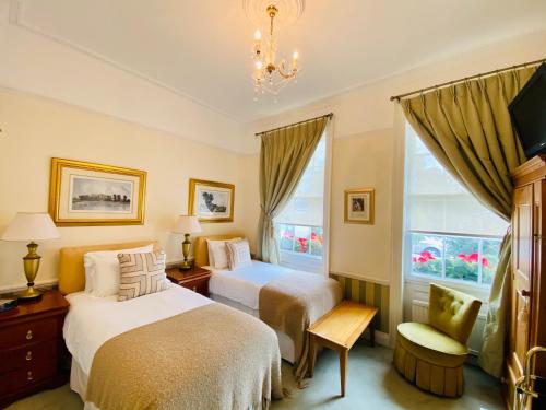 a bedroom with two beds and a chair and a window at Pier View Self Catering Luxury Apartments in Southend-on-Sea