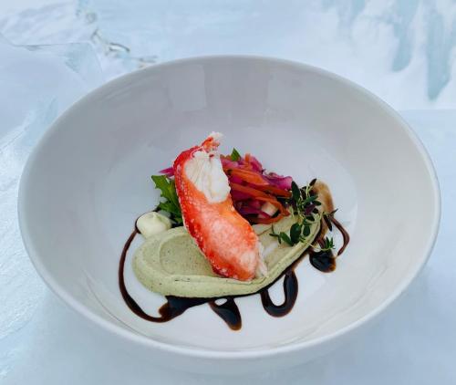 a white plate with a dish of food on a table at Aurora Village Ivalo in Ivalo