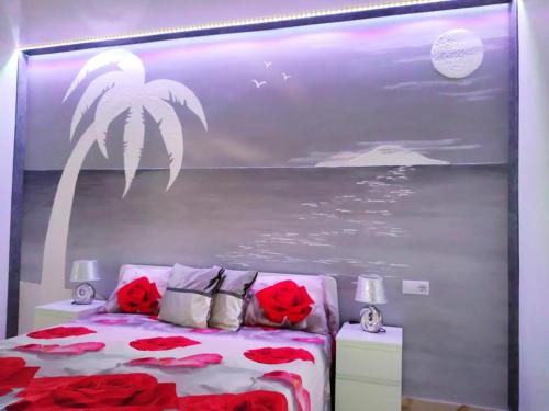 a bedroom with a bed with red flowers on it at Ocean View Elegant Magic Apartment in Palm-Mar