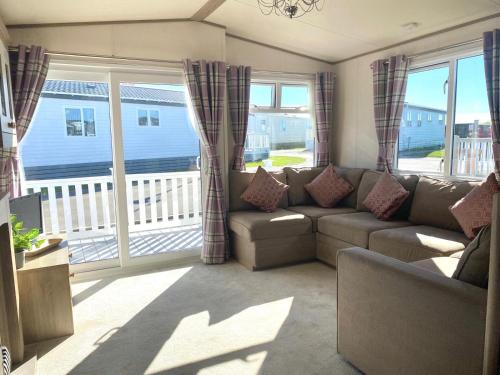 sala de estar con sofá y balcón en 37 Bay View Oceans Edge by Waterside Holiday Lodges, en Lancaster