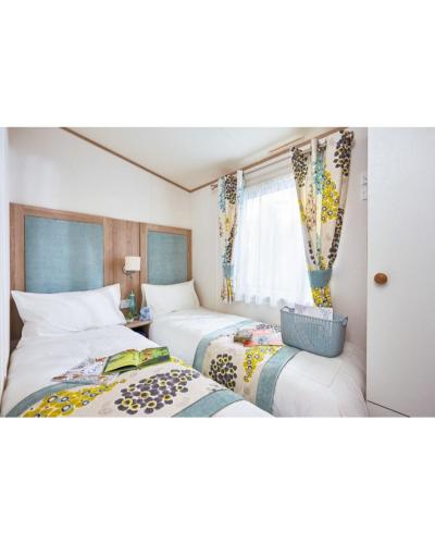 ランカスターにある37 Bay View Oceans Edge by Waterside Holiday Lodgesのベッド2台と窓のある寝室