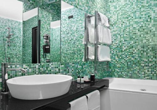een badkamer met een wit bad en groene tegels bij LHP Suite Roma Piazza di Spagna in Rome